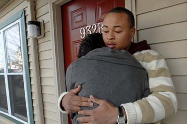 Sergio Rivera's brother, James Harris, hugs Sergio's girlfriend, Daja Chambers, who was clutching Sergio's athletic jersey from high school as she wept. (April Saul / Staff Photographer)