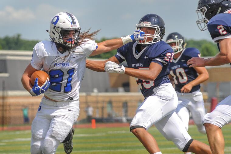 Quakertown's Michael Terra (21) pulls away from Central Bucks East's Klay Slifer (25) on a second-quarter touchdown reception.