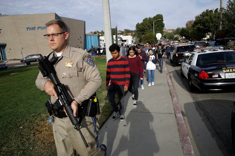 Students are escorted out of Saugus High School after reports of a shooting on Thursday, Nov. 14, 2019, in Santa Clarita, Calif.
