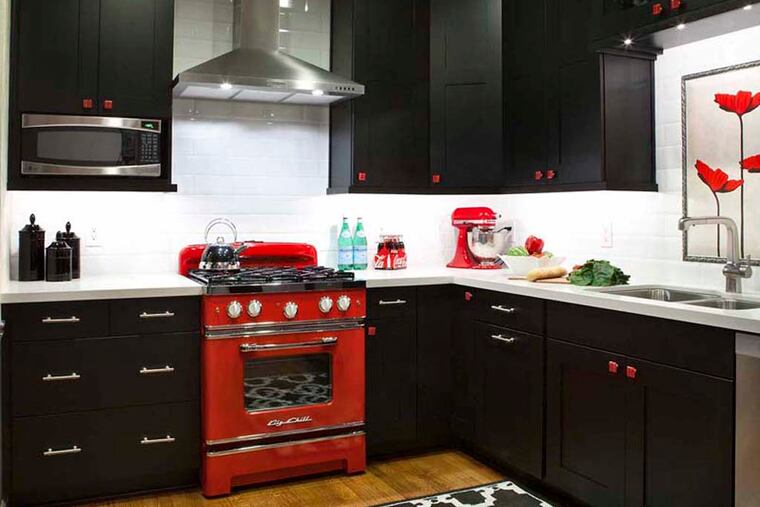 A 14-by-12 foot Atlanta kitchen designed by Kandrac & Kole Interior Designs features black cabinets with red hand-blown glass knobs, a retro red stove from Big Chill, a red mixer and, this being Atlanta, Coca-Cola. Illustrates DESIGN-KITCHENS (category l), by Jura Koncius, (c) 2014, The Washington Post. Moved Thursday, October 30, 2014. (MUST CREDIT: Jill Buckner Photography.)