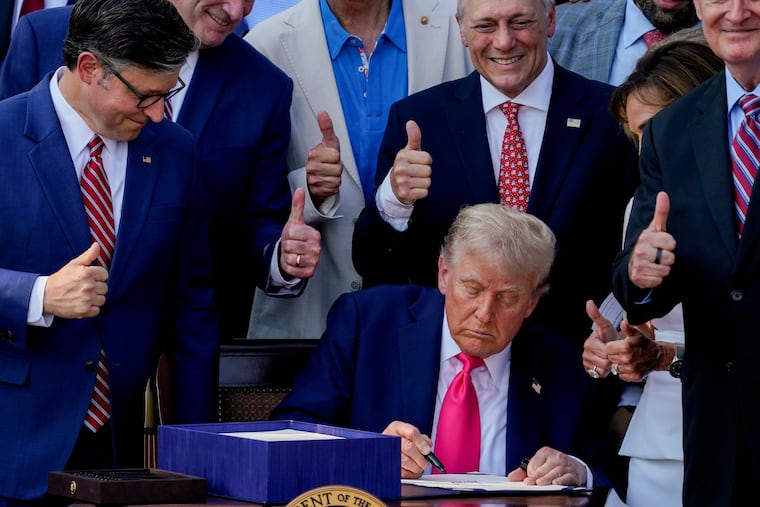 President Donald Trump signs the One Big Beautiful Bill Act at the White House on July 4 as House Speaker Mike Johnson and other Republicans look on.