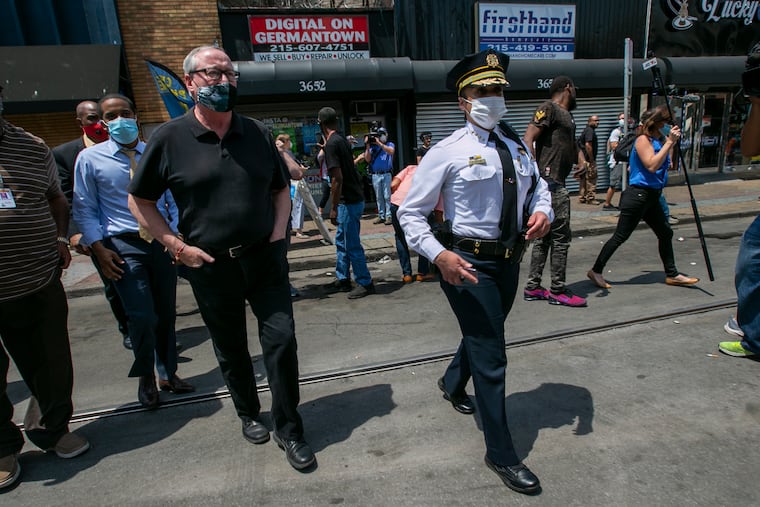 In this June 4, 2020, file photo, Philadelphia Police Commissioner Danielle Outlaw (right) and Mayor Jim Kenney (left) meet with people in Philadelphia after days of protest over the May 25 death of George Floyd. On Jan. 28, Outlaw defended her actions during days of widespread protests against police brutality this summer after an independent report harshly criticized her direct decision-making.