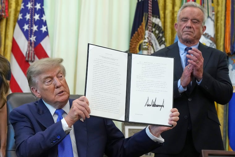 President Donald Trump holds a signed executive order about vaccines as Health and Human Services Secretary Robert F. Kennedy Jr. looks on, Monday in the Oval Office. The administration’s continued muddling of vaccination messages has obvious risks, writes the Editorial Board.
