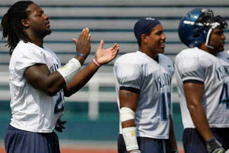 Linebacker Osayi Osunde, left, applauds his teammates during Villanova University football media day practice on Aug. 19. (David Maialetti / Staff Photographer)