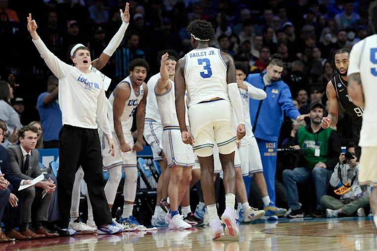 The UCLA bench celebrates a three-pointer basket Eric Dailey Jr. (center) during its win over Central Florida.