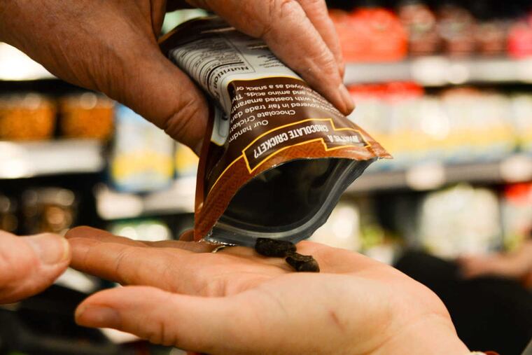 Stu Bykofsky pours out some Chocolate Crickets for Nissa Eisenberg of Fairmount to try at MOM's Organic Market in Center City.