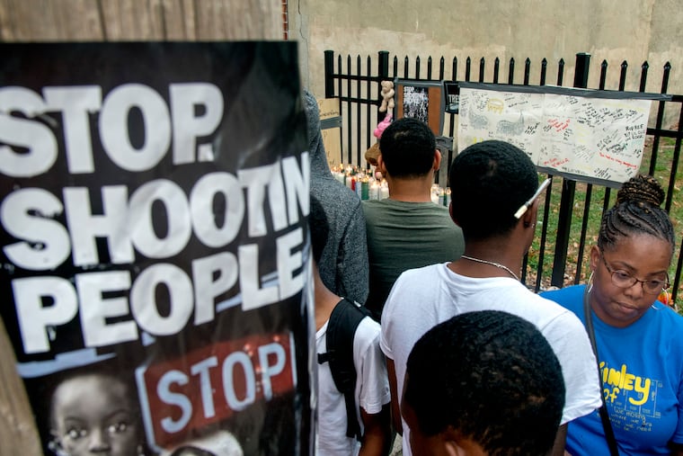 Neighbors attend a vigil Tuesday evening for 14-year-old Tyree Bates, where he was shot in the 2100 block of North Fourth Street.