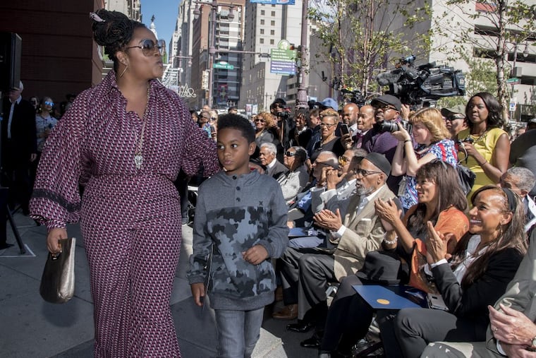 Philadelphia singer Jill Scott, walking with her son Jett Roberts, 8, blows kisses to some of her fans who attended the 2017 Philadelphia Music Alliance Walk of Fame ceremony on the Avenue of the Arts October 4, 2017. Applauding Ms. Scott are (from left) Kathy and Kim Sledge from the group Sister Sledge, and songwriter/record producer Ken Gamble.