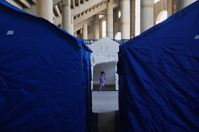 A child stands between tents Tuesday set up inside Beirut's Camille Chamoun Sports City Stadium, which has been turned into a shelter for people displaced by Israeli airstrikes in southern Lebanon.