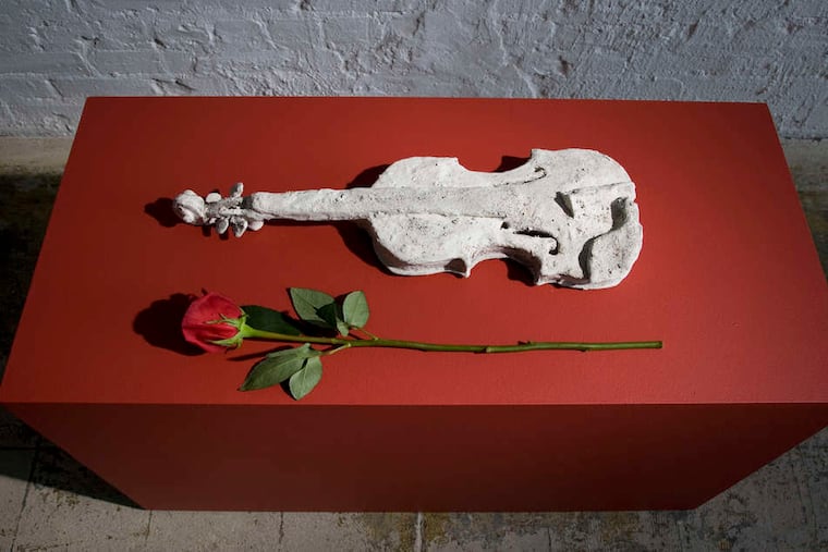 "The Sweetness of Music," above, made by Laurie Anderson of mud, clay, and the ashes of her terrier Lolabelle; the violin is Anderson's signature instrument. Left, "Lola- belle in the Bardo," one of a series of 10 huge charcoal-on- paper drawings. The exhibit, "Forty-Nine Days in the Bardo," also includes a half-dozen tiny videos projected onto clay figures of people in a dark room.