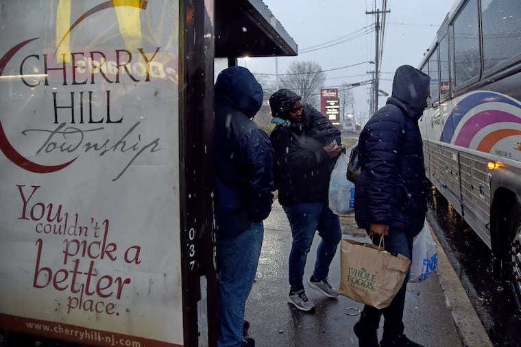 Shoppers get on the bus with their groceries as snow begins to fall at the Ellisburg Shopping Center on Route 70 in Cherry Hill.