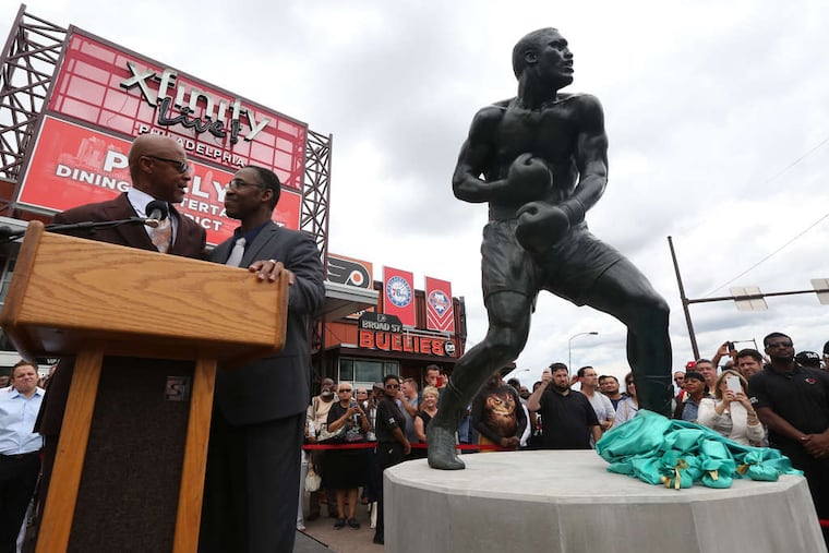 His son, and former heavyweight boxer Marvis Frazier (right), and Rev. Blane Newberry from Enon Tabernacle Baptist Church bless a 12-foot-tall, 1,800-pound bronze statue of "Smokin'" Joe Frazier after it was unveiled in 2015 at XFinity Live in South Philadelphia.
