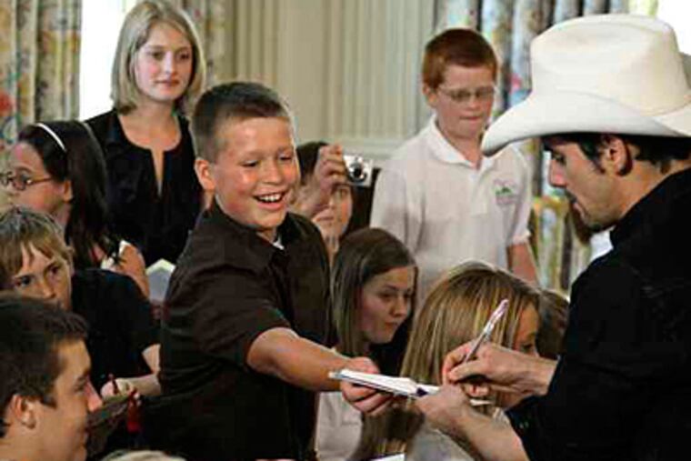 Country-music star Brad Paisley signs autographs as he leaves a Q-and-A with Alison Krauss for the White House Music Series.