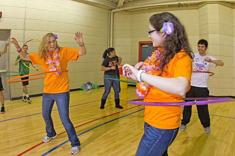 Julia England (left) and Sami Musumeci, Relay for Life co-chairs, with hula hoops during the benefit. DAVID M WARREN / Staff Photographer