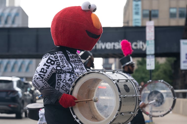“Philly Elmo” plays with the Positive Movement Entertainment (PME) Drumline outside the World Cafe Live during a town hall meeting on Thursday, July 10, 2025.