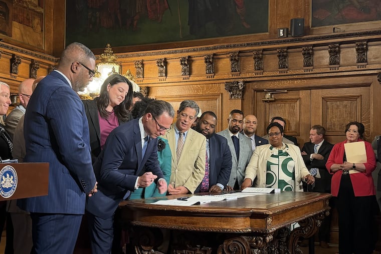 Gov. Josh Shapiro, flanked by fellow state Democrats, signs the 2026-27 Pennsylvania state budget in Harrisburg, Pa. on Sunday, July 12, 2026.
