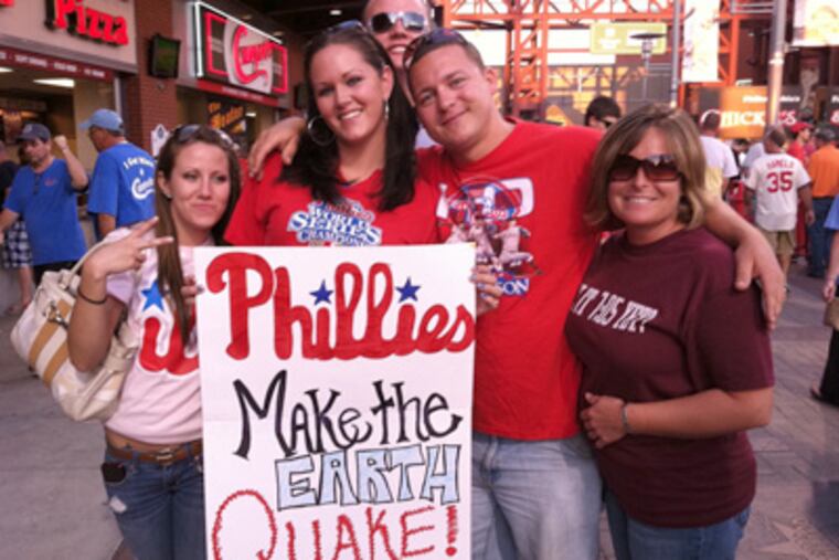 Ashley Messick, 26, of Mt. Ephraim, N.J., holds up a sign about the earthquake at Tuesday night's Phillies game at Citizens Bank Park. (Michael Vitez / Staff)