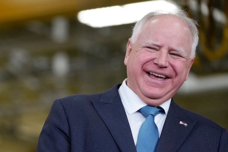 Minnesota Gov. Tim Walz laughs during a visit to the Cummins Power Generation Facility in Fridley, Minn., with Fridley's mayor, in April 2023. (AP Photo/Carolyn Kaster, File)