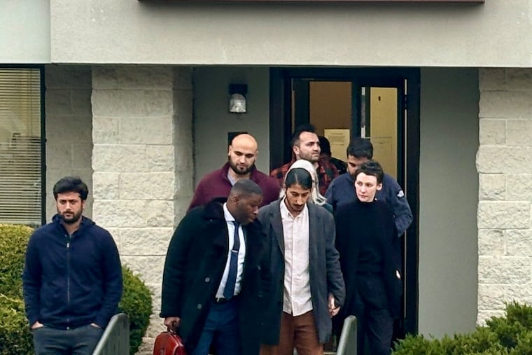 Mirvan Dinler (center) speaks with his attorney, Shaka Johnson, as they leave district court in Newtown Square. Dinler, 26, has been charged with raping a Villanova University student inside her dorm room after she hired him to drive her there in an Uber.