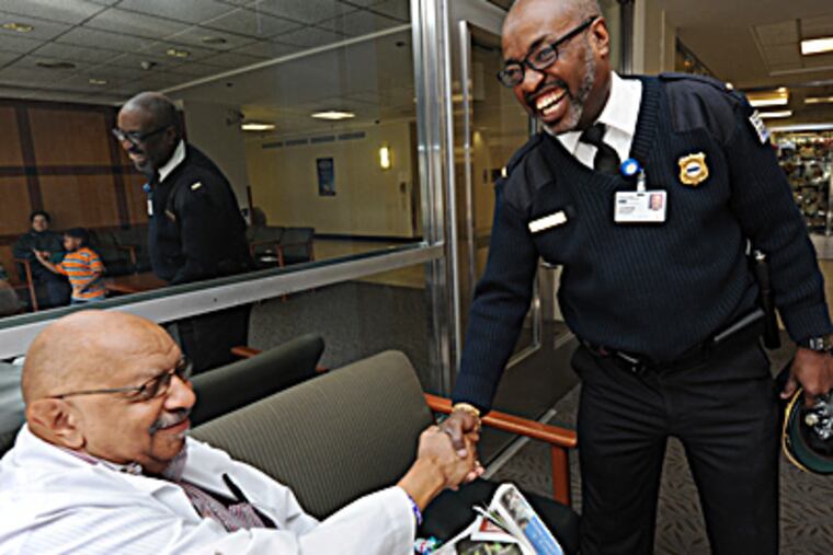 At Einstein, security supervisor Andy Wright (right) greets lab tech Hobson Gross. Wright gives $1,500 a year to the foundation. (APRIL SAUL / Staff Photographer)