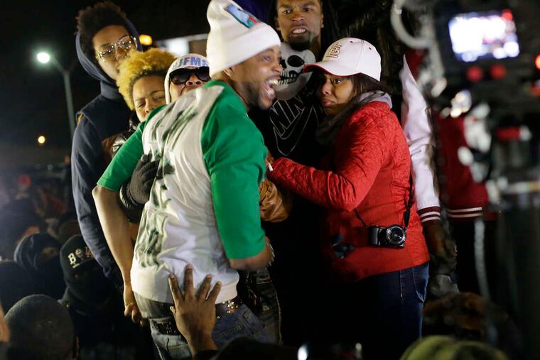 Lesley McSpadden (wearing sunglasses), the mother of Michael Brown, reacts to the announcement in Ferguson, Mo. CHARLIE RIEDEL / AP