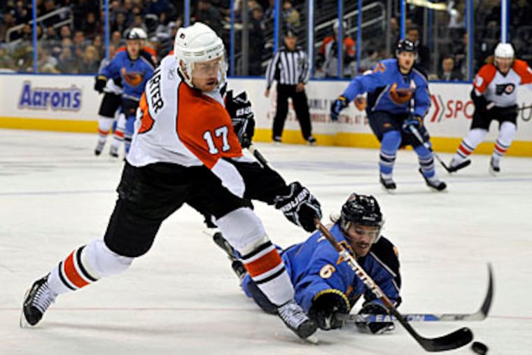 Atlanta Thrashers defenseman Ron Hainsey (6) goes to the ice as he tries to stop a shot from Philadelphia Flyers center Jeff Carter (17) during the third period. The Thrashers won 1-0. (AP Photo/Gregory Smith)