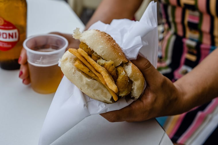 Author Katie Perla with a panelle chickpea patty and cazzilli potato croquette sandwich