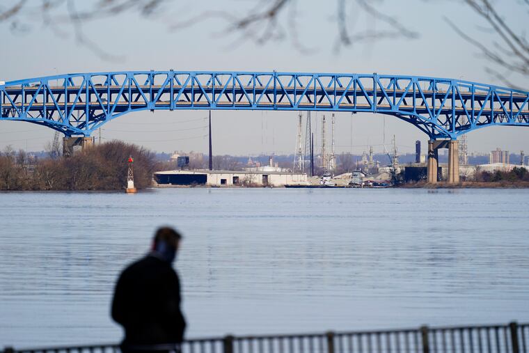 A walker makes their way past the Interstate-95′s mile-long double-decked Girard Point Bridge in Philadelphia. A state court on Thursday, June 30, 2022, permanently blocked Gov. Tom Wolf's plan to toll as many as nine major bridges on interstates in Pennsylvania. The Girard Point Bridge was one of the bridges under consideration for tolling.