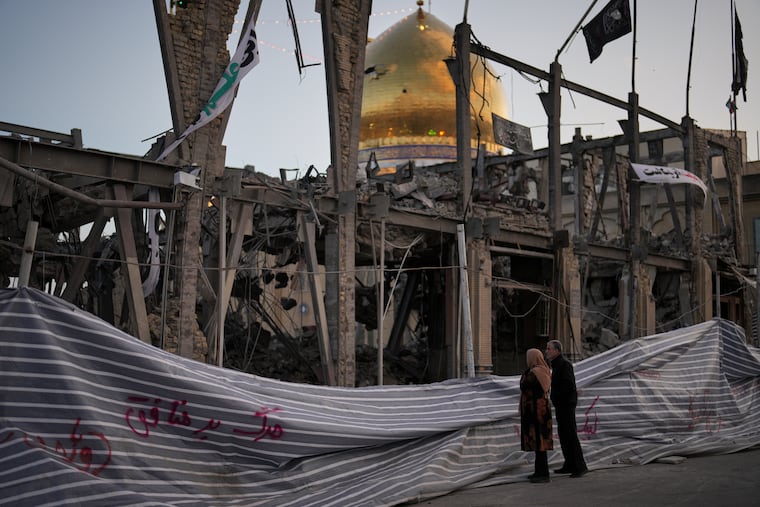 Pedestrians look at a destroyed building within the Grand Hosseiniyeh, with the mosque visible in the background, which officials at the site say was hit by U.S.-Israeli airstrikes Tuesday, in Zanjan, Iran, Saturday, April 4, 2026.