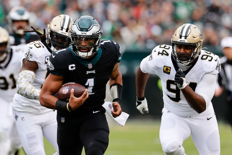 Eagles quarterback Jalen Hurts runs with the football against the New Orleans Saints defense on Nov. 21, 2021.