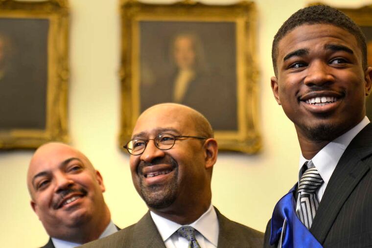 Philadelphia Distict Attorney-for-a-day Andre Jackson (right) stands with his mentor, Seth Williams (left), and Mayor Nutter during ceremonies in City Hall to begin the 40th annual Lockheed Martin PAL Day. Story, B2.