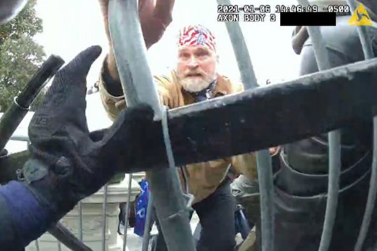 A man the FBI has identified as Philip S. Young, a retired boilermaker from Sewell, N.J., pushes against police barricades outside the Capitol in this still from a Metropolitan Police officer's bodycam.