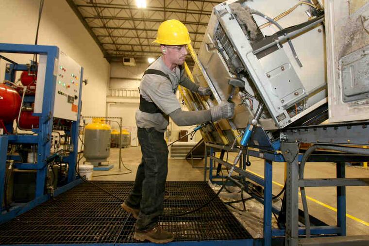 At Jaco in Hatfield, Andrew MacNair removes refrigerant and oil from an old refrigerator before it can be destroyed/recycled.