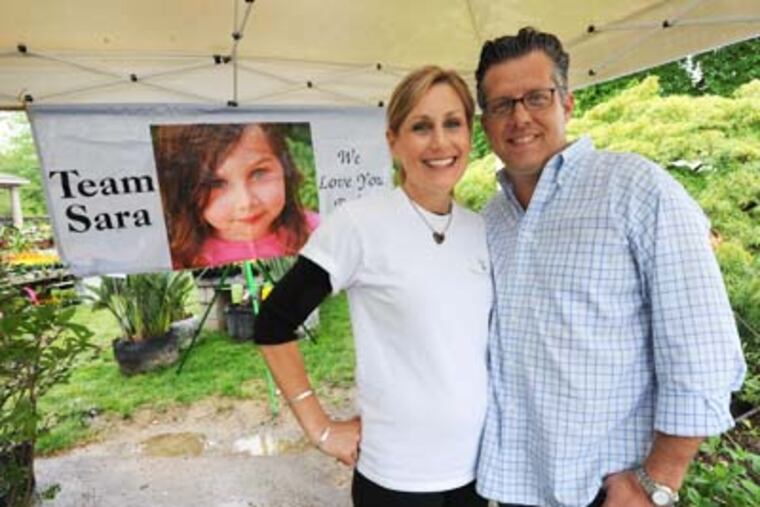 Jen and Kevin Burke, who lost their five-year old daughter Sara to a brain tumor prepare for their Mother's Day plant sale to raise money for critically-ill children at Burke Brothers Landscaping in Wyndmoor on May 3, 2012. APRIL SAUL / Staff Photographer