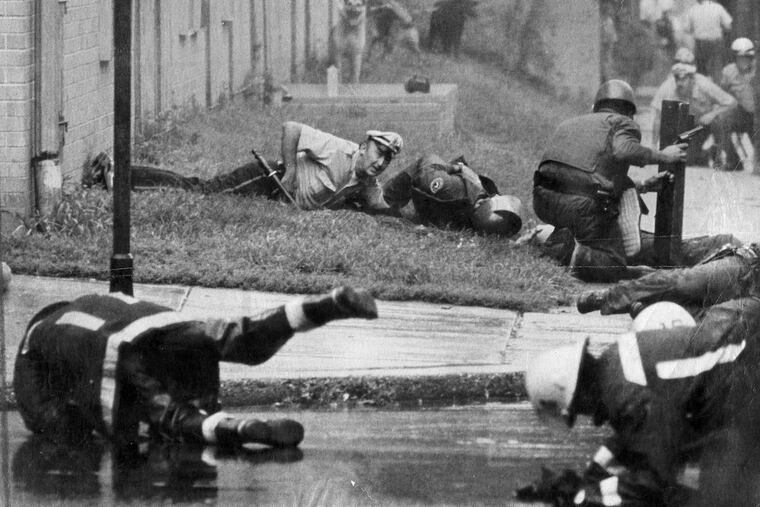 Philadelphia policemen and fireman react as gunfire starts and officers are shot during the August 8, 1978 confrontation with MOVE on Powelton Ave. Ron Williams / Philadelphia Journal via UPI