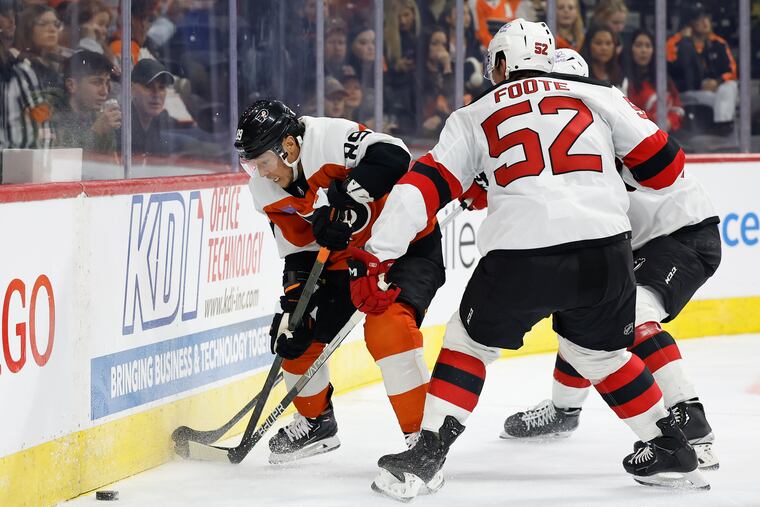 Flyers right wing Cam Atkinson looks down at the puck against New Jersey Devils defenseman Cal Foote in the second period during a preseason game on Saturday, Sept. 30, 2023.
