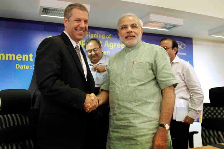 Ford official Joe Hinrichs (left) with Narendra Modi, an official of Gujarat, India, where the automaker will invest $1 billion and hire 5,000 workers.