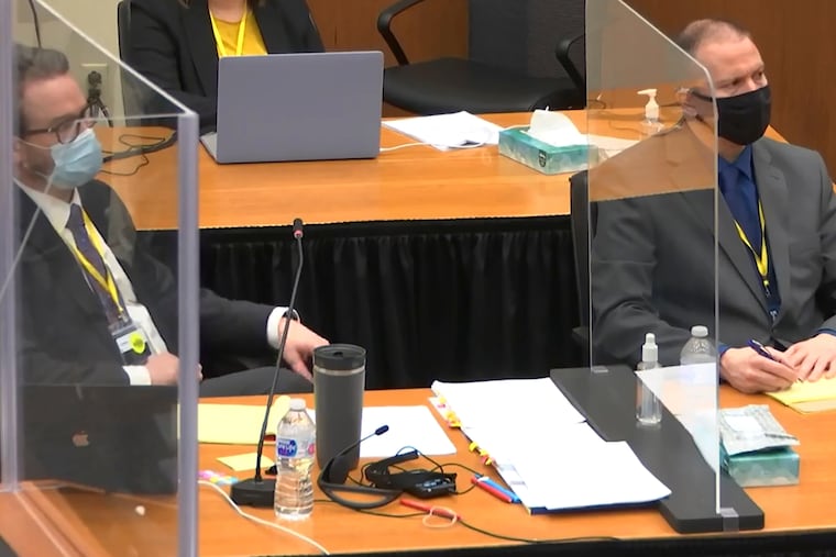 In this image taken from video, defense attorney Eric Nelson, left, and defendant Derek Chauvin listened as Hennepin County Judge Peter Cahill presided over jury selection Wednesday.