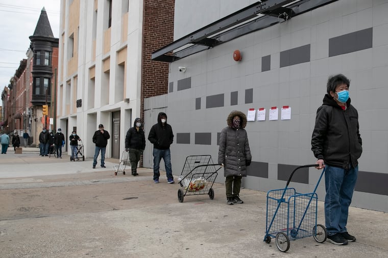 People lined up outside of the Bethany Miracle Center for free meals distributed by SEAMAAC in South Philadelphia last spring.