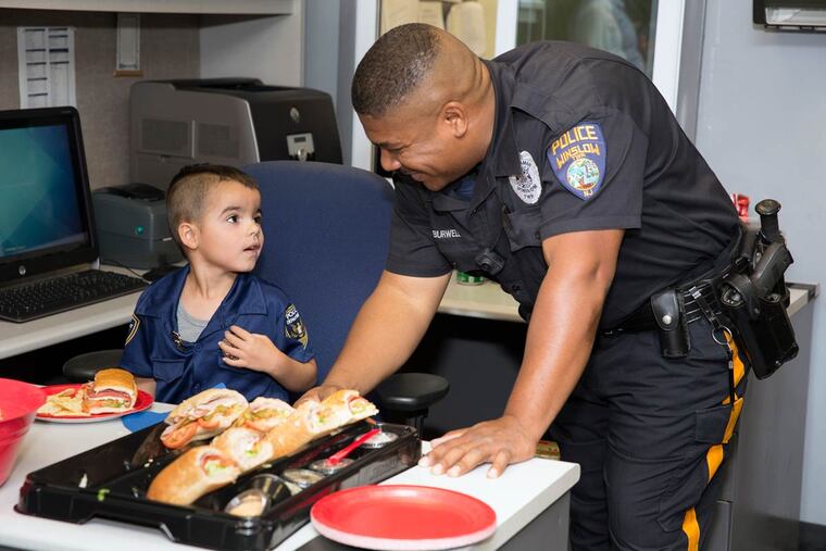 William Evertz Jr. visits with Police Officer George Burwell at the Winslow Township police headquarters.