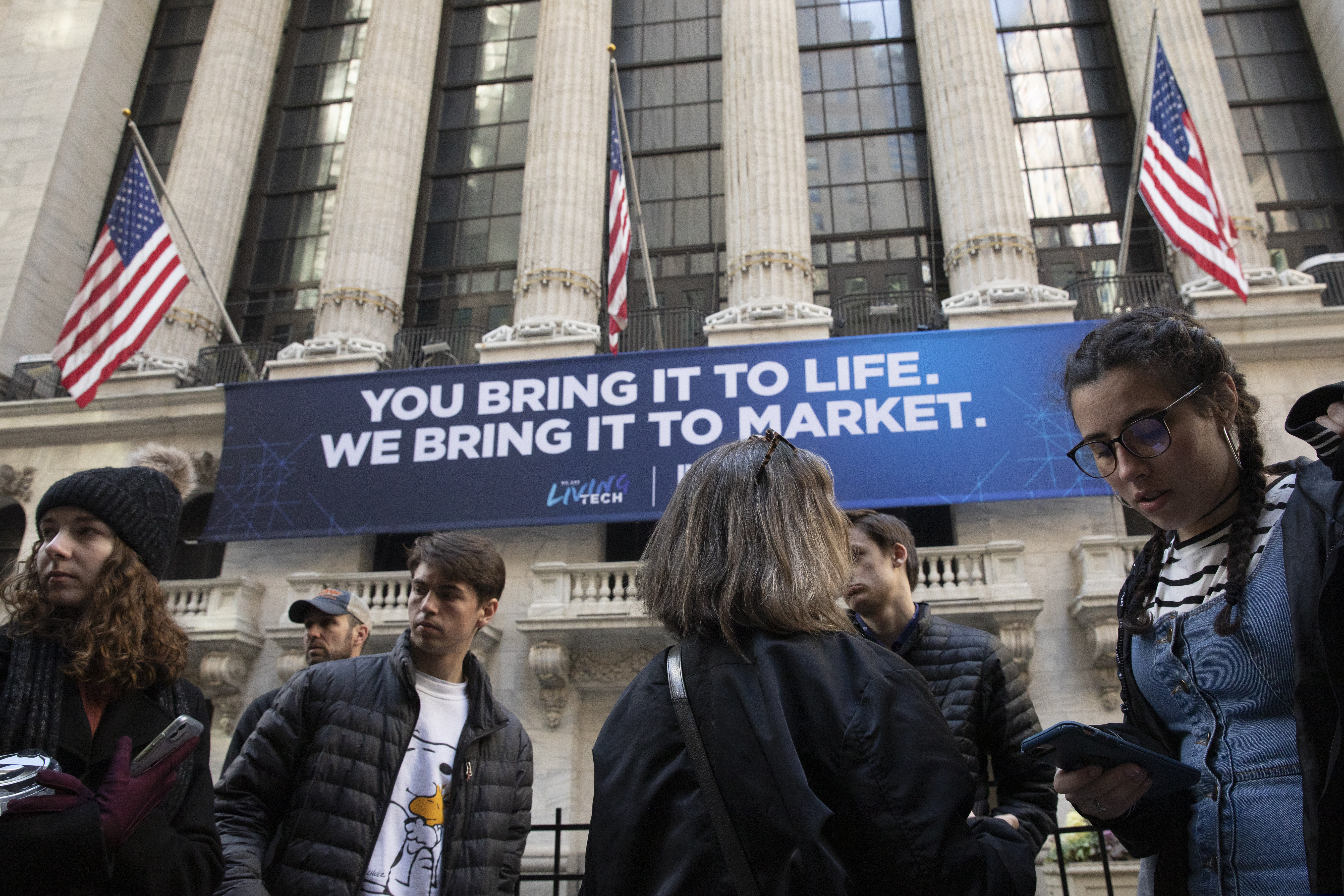 In this March 9, 2020 file photo, people stop to look at the New York Stock Exchange. Stocks are opening sharply lower on Wall Street Wednesday as fears of economic fallout from the coronavirus outbreak grip markets again.