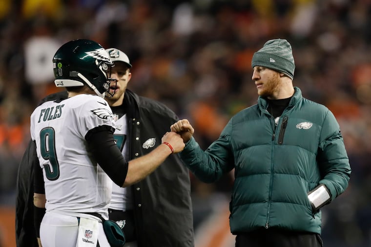 Nick Foles fist-bumps Carson Wentz (right) during the Eagles' 16-15 victory over the Chicago Bears in Sunday's wild-card game.
