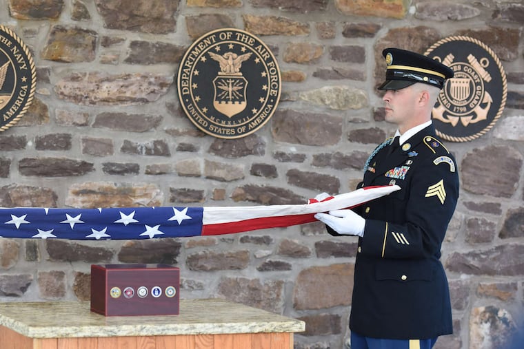 In this file photo, Staff Sgt. John Westfall (left) and Sgt. Thomas Morris perform the flag-folding ritual at the service for veterans buried at the Washington Crossing National Cemetery.