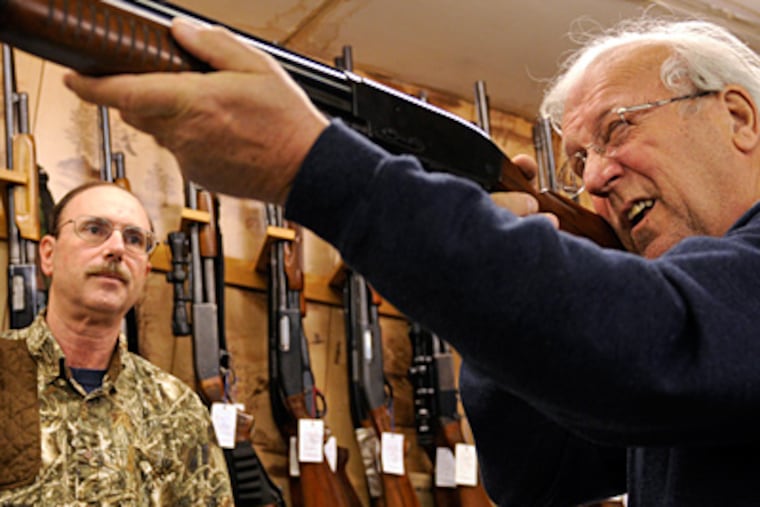 Ed Tarpy watches as Jerry Fraley, 69, of Blackwood, checks out a gun at Tarpy's shop in Deptford. Gun laws in New Jersey are among the toughest in the United States. (Tom Gralish / Staff Photographer)