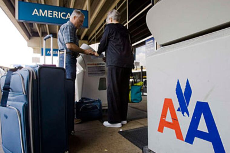 Travelers check luggage outside the American Airlines terminal at Phila. Airport. Joining US Airways would quicken nonstop flights to Asia. (AP file photo)