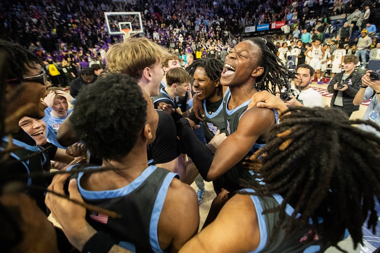 Teammates swarm around Kevair Kennedy of Father Judge after they defeated Roman Catholic 41-34 in the Philadelphia Catholic League boys championship at The Palestra on Feb. 23, 2025.