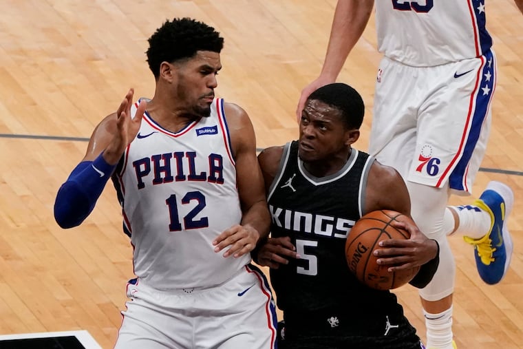 Sixers forward Tobias Harris tries to stop the drive of Sacramento Kings guard De'Aaron Fox.