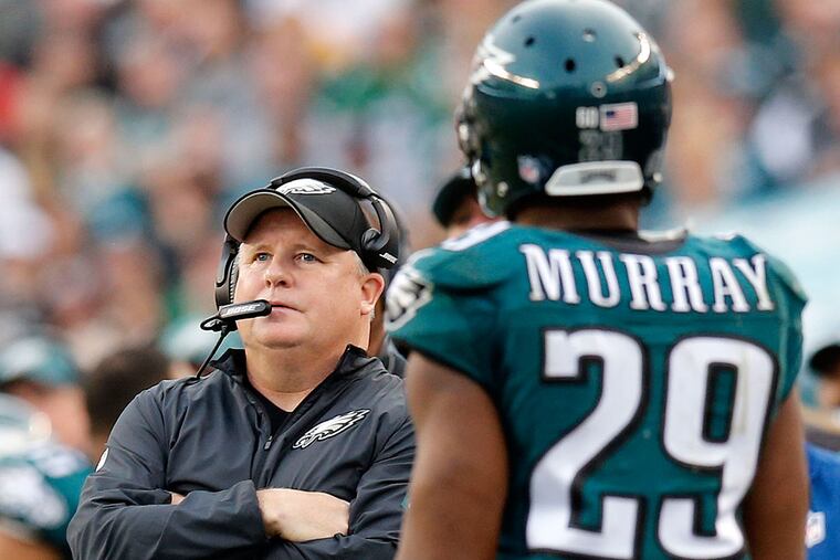 Eagles head coach Chip Kelly look up at a replay next to DeMarco Murray.