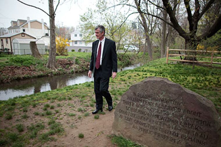 Michael T. Sellers of Newtown Borough Council stands next to Newtown Creek, which a Bucks County group has been rallying to restore to its former place of prominence in the historic town. (David Swanson / Staff Photographer)