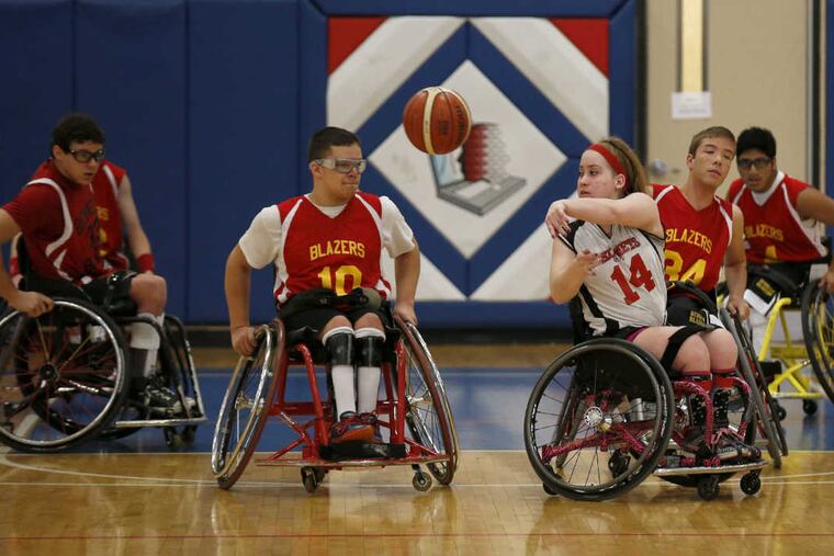 Katies Komets' Natalie Kolander (#14) passes the basketball past Bennett Blazers' Sean Thomason (#10) during the 19th Annual Katie Kirlin Junior Wheelchair Basketball Tournament at the Microsoft's School of the Future in West Philadelphia on Sunday, January 22, 2017 in Philadelphia. YONG KIM / Staff Photographer
